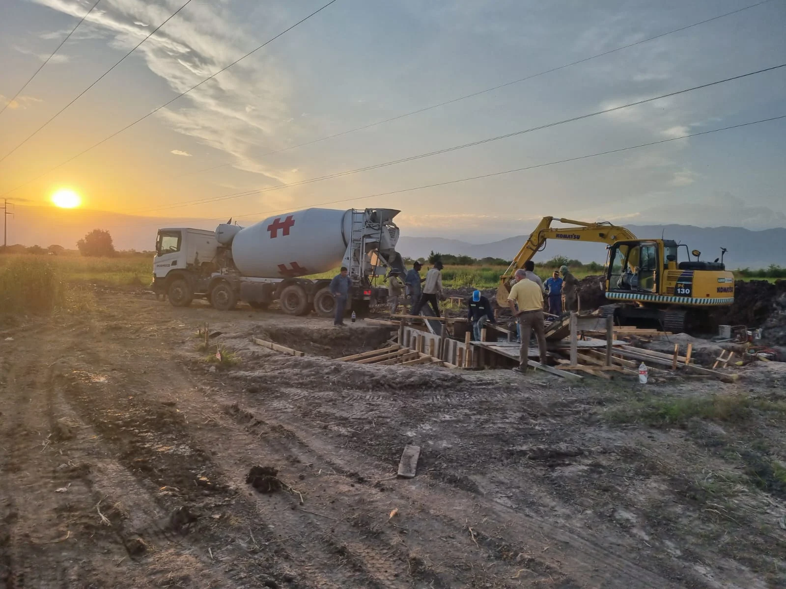 Equipo trabajando en una obra de Helguera al atardecer